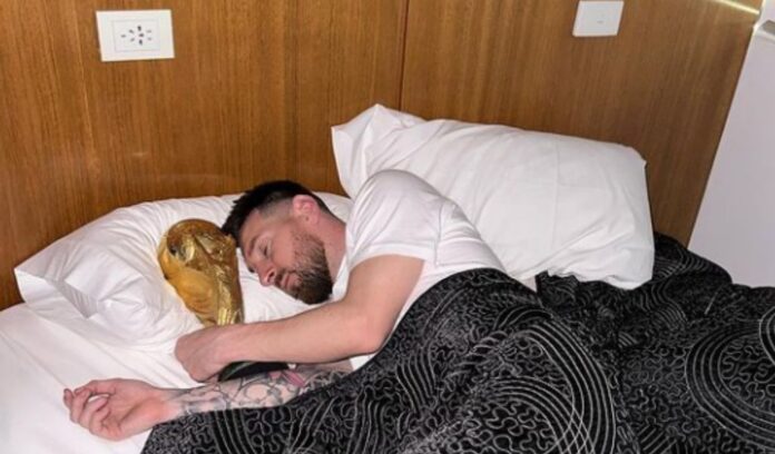 Lionel Messi poses in bed with World Cup trophy