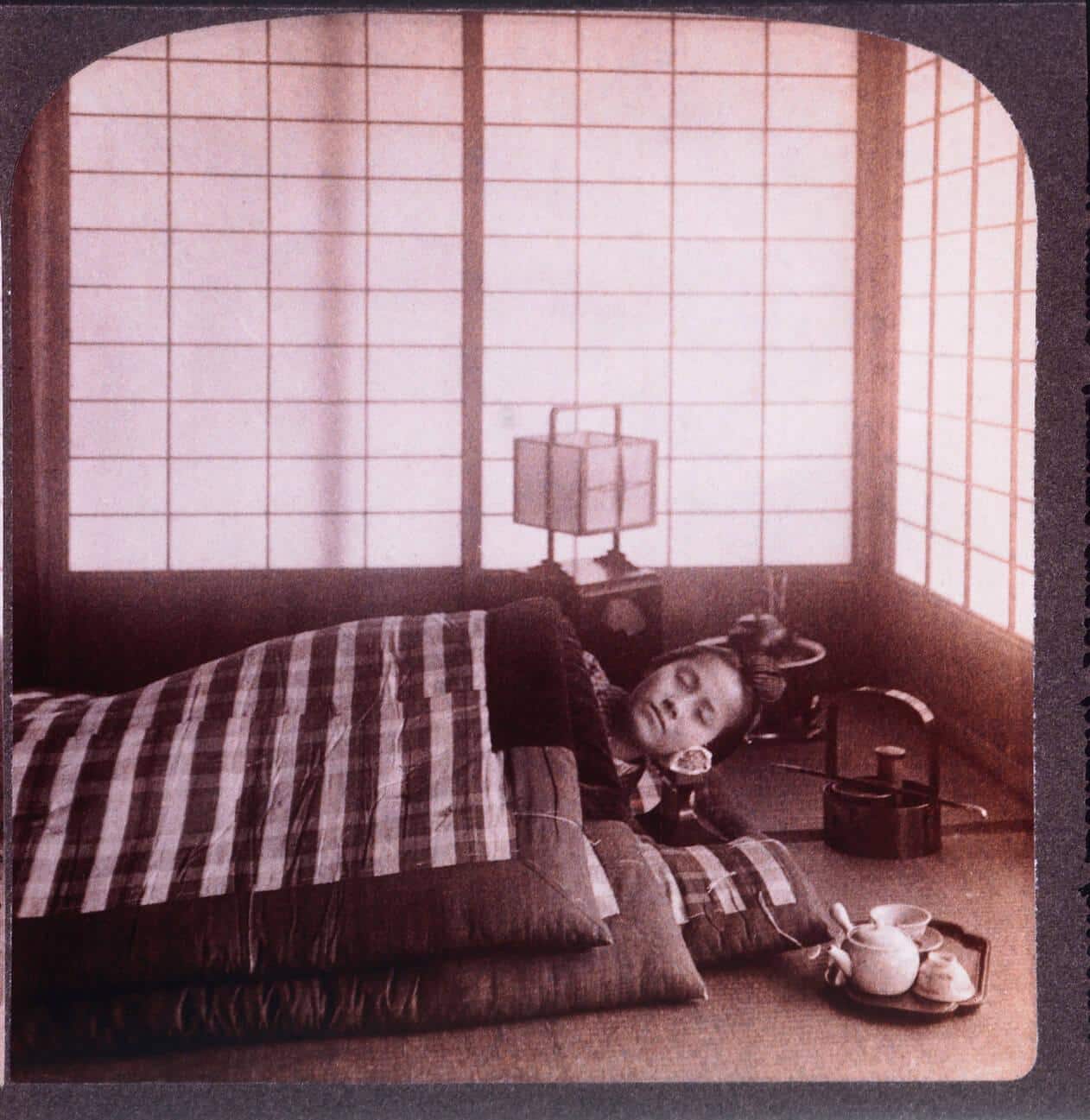 Young Japanese Woman Sleeping Between Futons