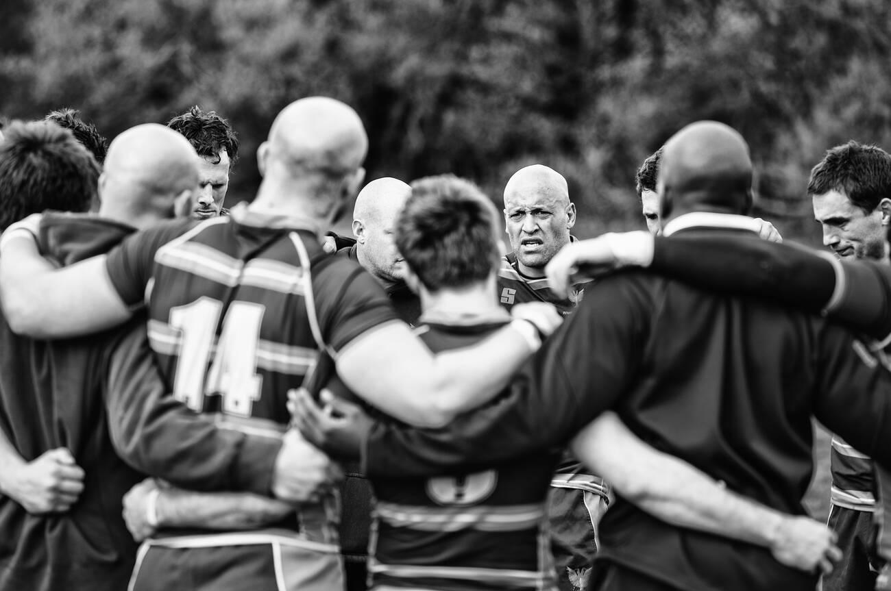 Rugby players huddle after a victorious match