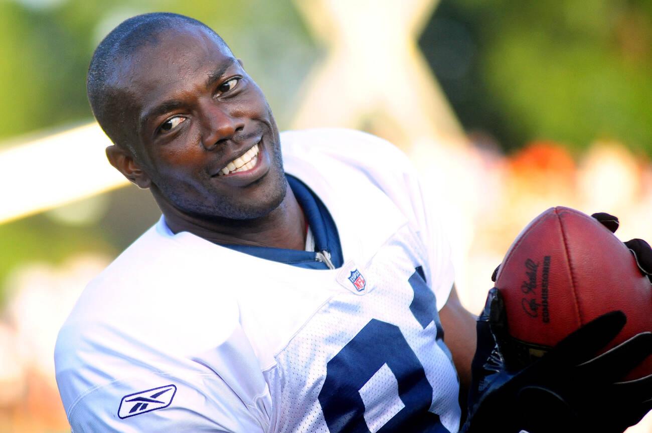 Buffalo Bills wide receiver Terrell Owens cracks a smile as he plays catch on the sideline