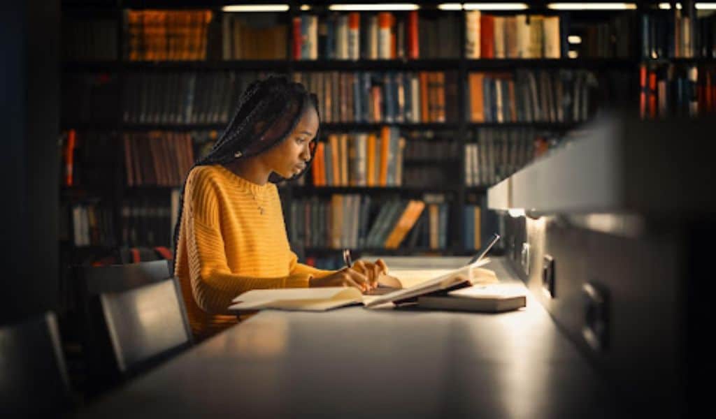 young girl in university library studying at night