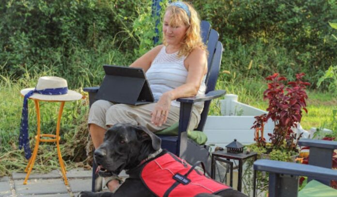 older adult woman with a service dog on a patio