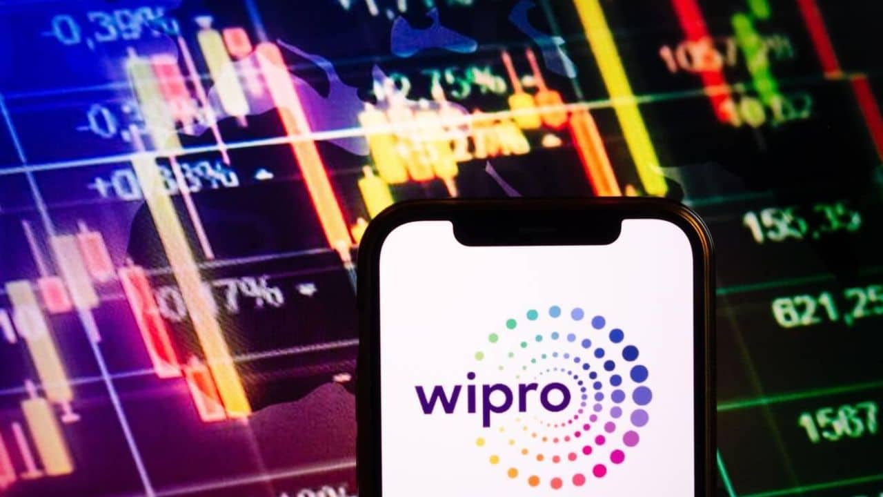 Smartphone displaying logo of Wipro company on stock exchange diagram background