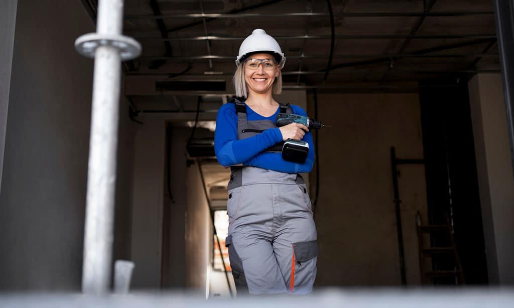 Female construction worker holding a power drill.