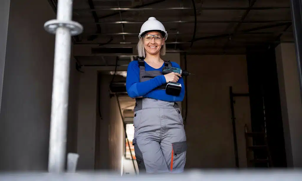 Female construction worker holding a power drill.