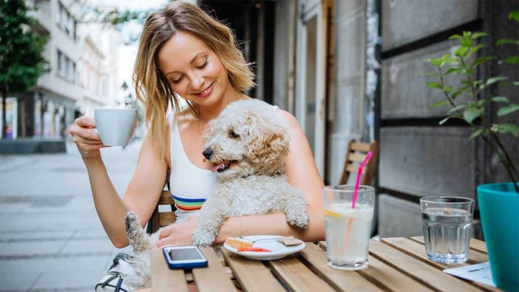 Enjoying coffee with a pet dog at an outdoor café.