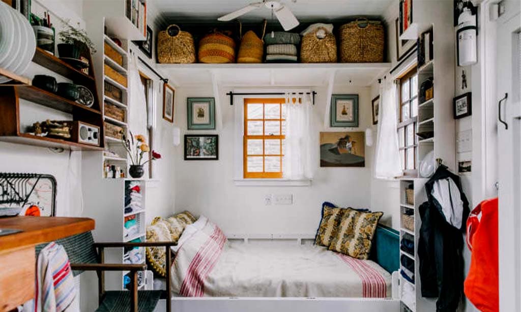 Cozy small room with organized shelves, comfy bed, and natural light